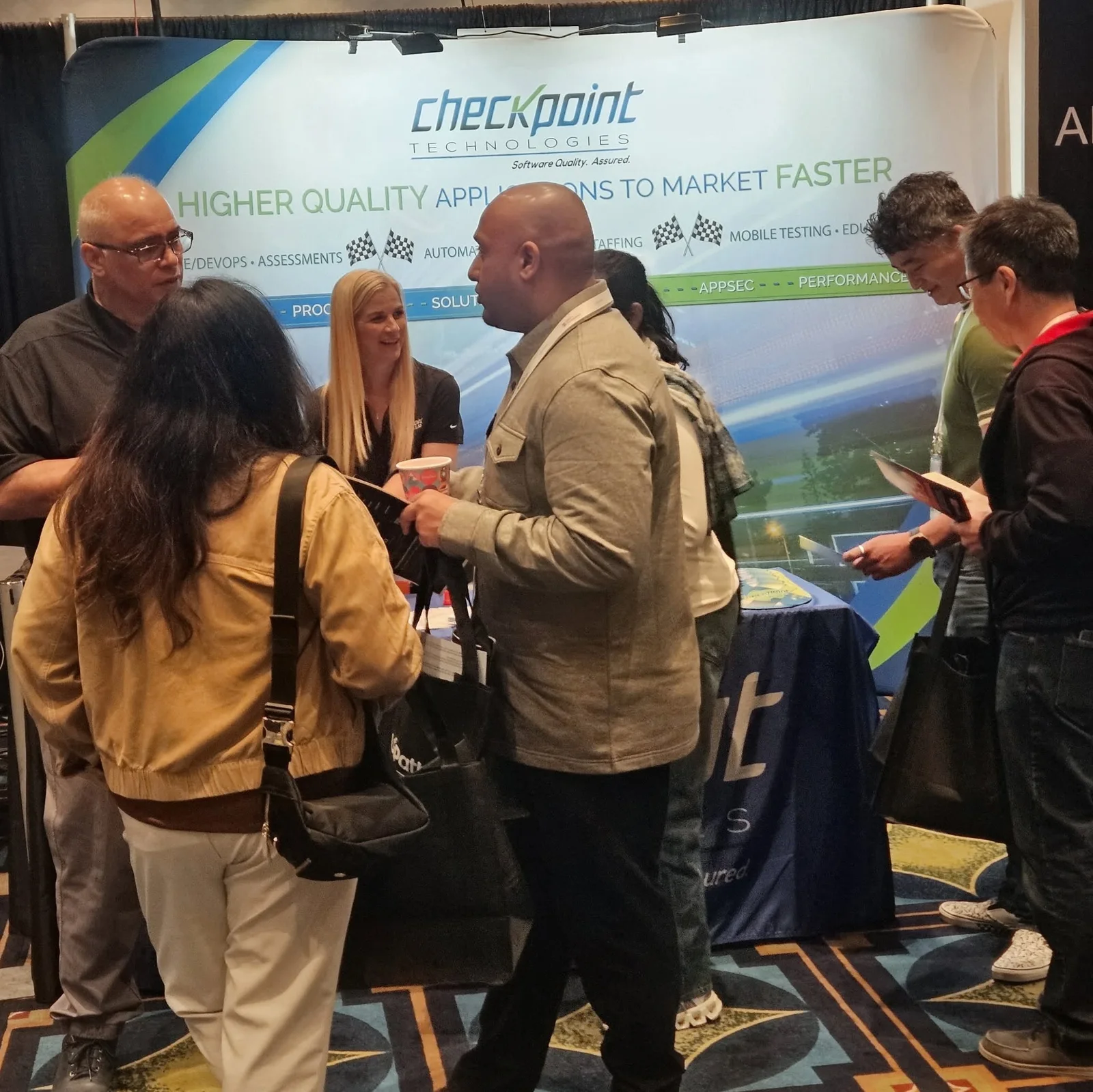 Conference attendees gathered for a conversation at an exhibit booth.